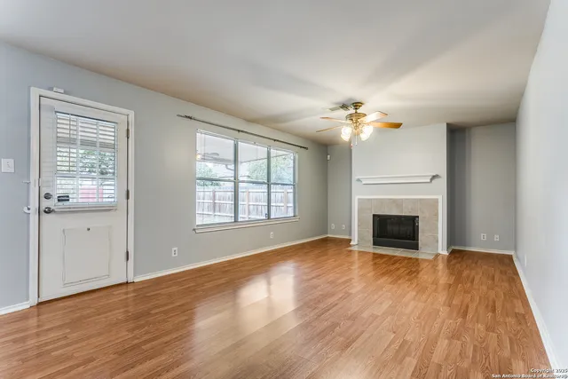 wooden floor fireplace and windows in an empty room