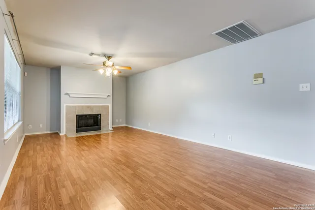a view of a livingroom with a fireplace and chandelier fan