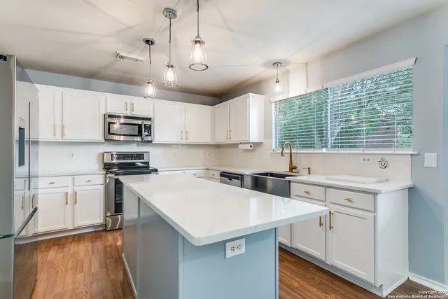 a kitchen with kitchen island a sink stainless steel appliances and cabinets