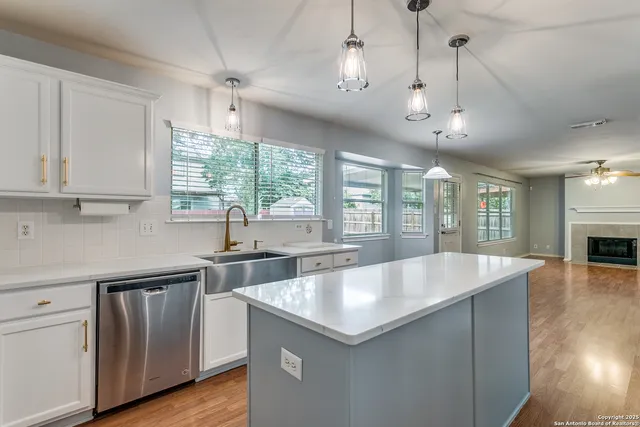 a large kitchen with kitchen island a large counter space a sink appliances and a window