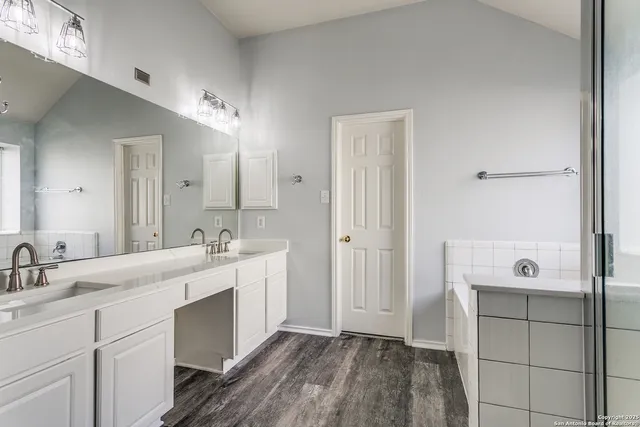 a spacious bathroom with a double vanity sink a mirror and shower
