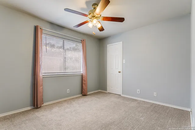 a view of a livingroom with a ceiling fan and window
