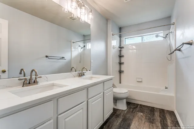 a bathroom with a double vanity sink toilet mirror and shower
