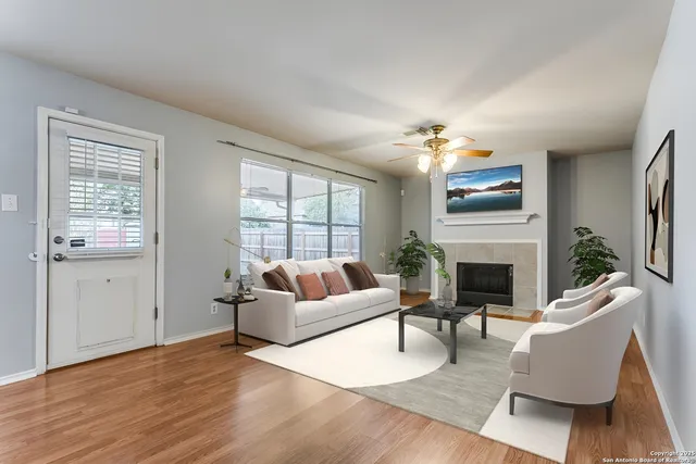 a living room with furniture a fireplace and a chandelier