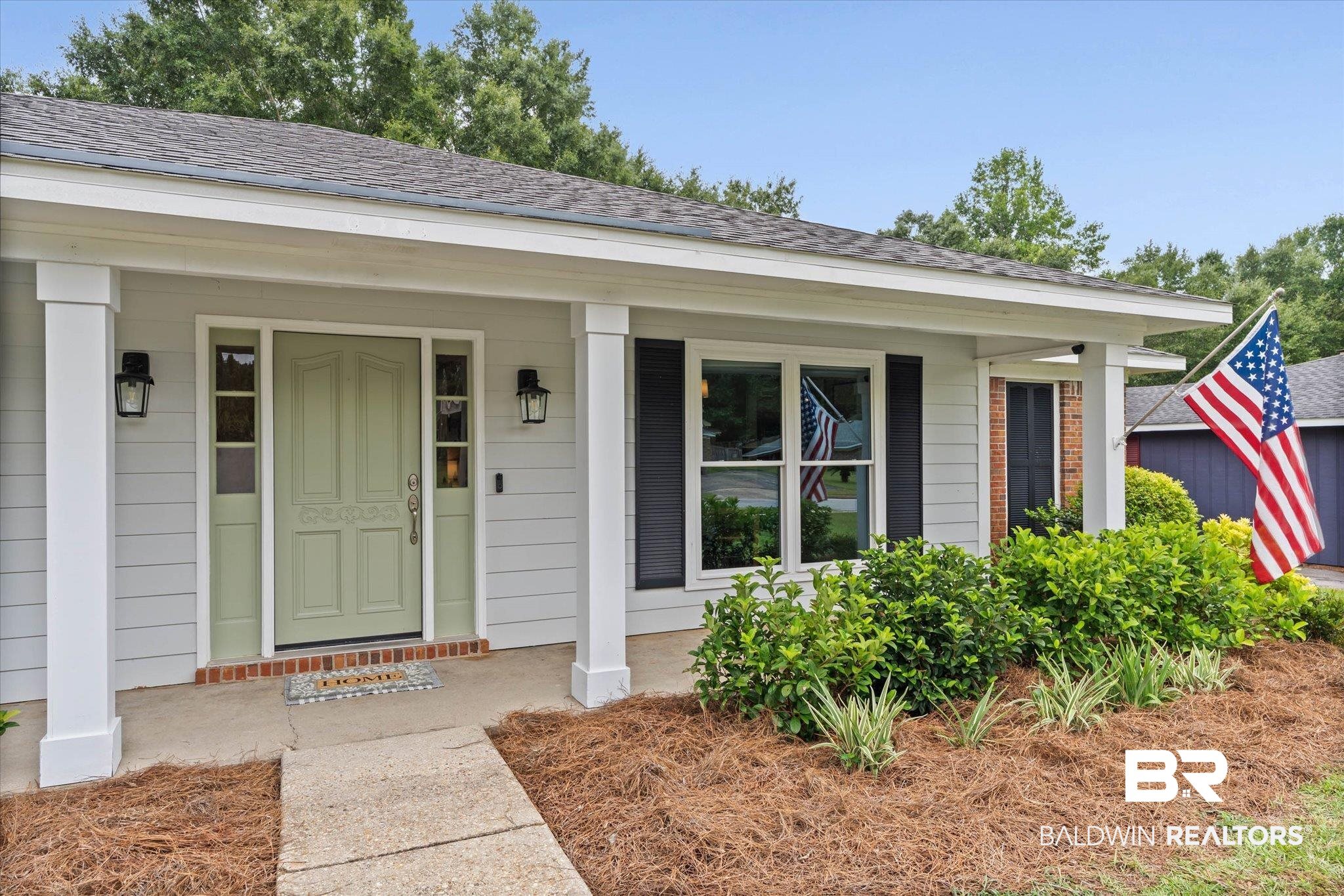 6501 Gas Light Lane South Mobile, AL 36695 - Photo 2 of 23 Light gray siding exterior with a sage green front door, flanked by sidelight windows and black sconces