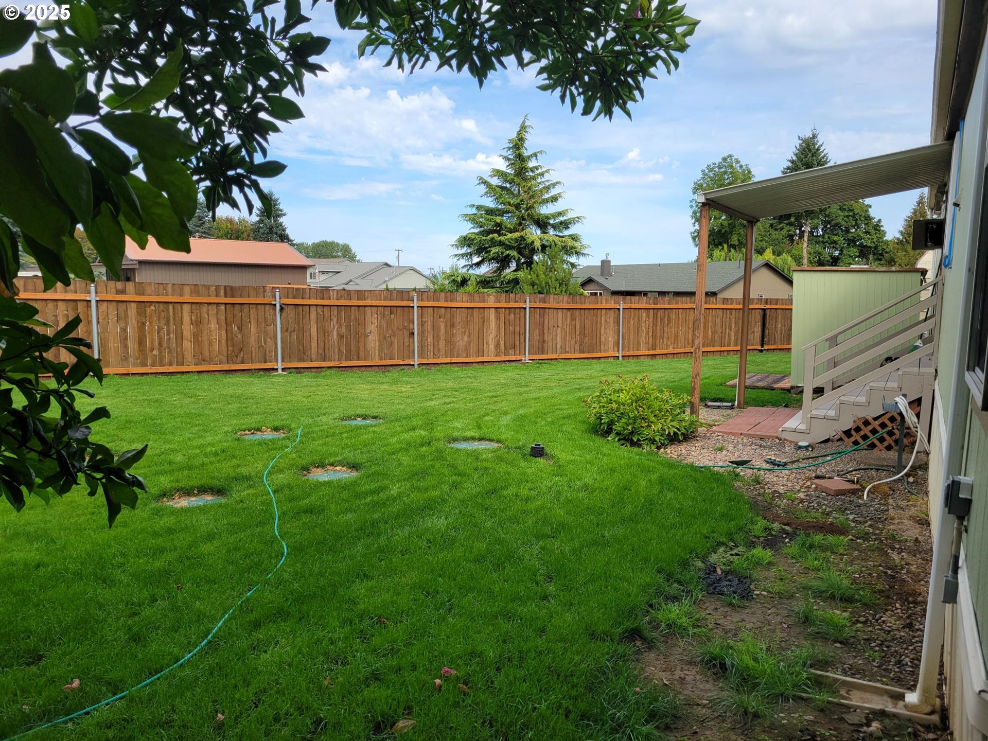 50551 Bark Way, Unit 47 Scappoose, OR 97056 - Photo 16 of 21 a view of a backyard of the house with plants and wooden fence