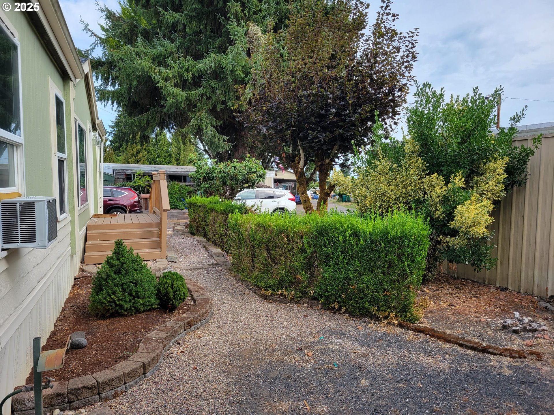 50551 Bark Way, Unit 47 Scappoose, OR 97056 - Photo 2 of 21 a view of a patio with table and chairs potted plants and large tree