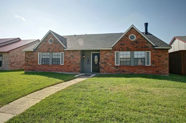a front view of a house with a yard and trees