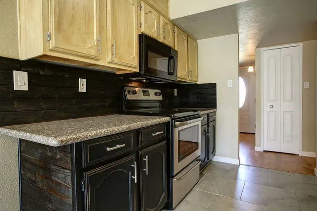 a kitchen with stainless steel appliances granite countertop a stove and a microwave