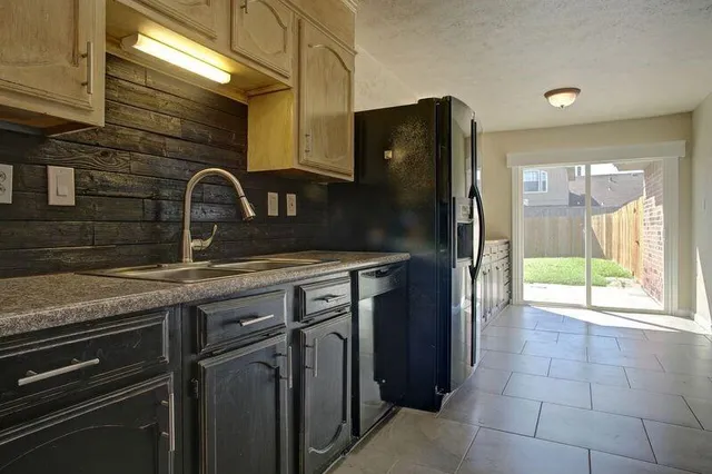 a kitchen with granite countertop a refrigerator and a sink