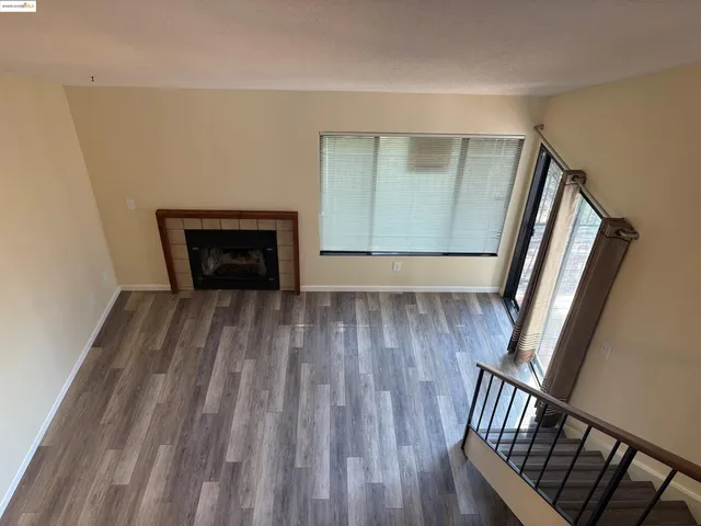 a view of a livingroom with wooden floor and staircase