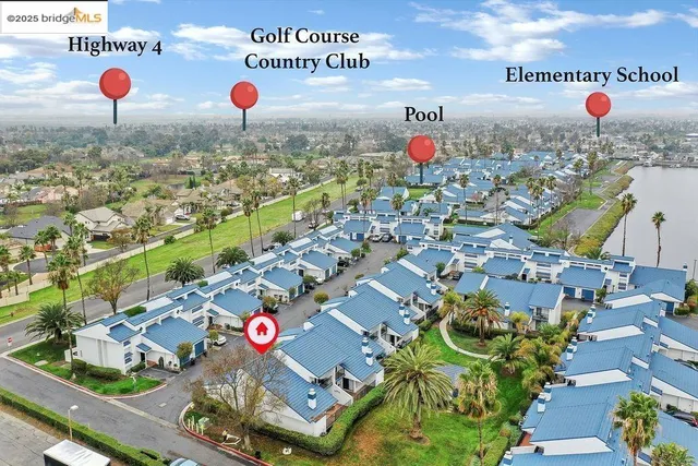 an aerial view of a city with lots of residential buildings ocean and mountain view in back