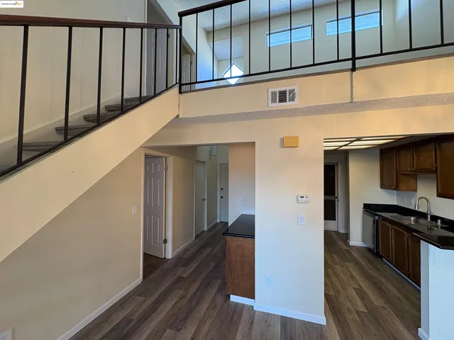 a hallway with wooden floor and staircase