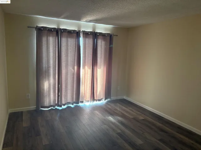 an empty room with wooden floor and a window