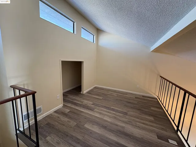 a view of a hallway with wooden floor and staircase
