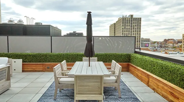 a view of roof deck with table and chairs