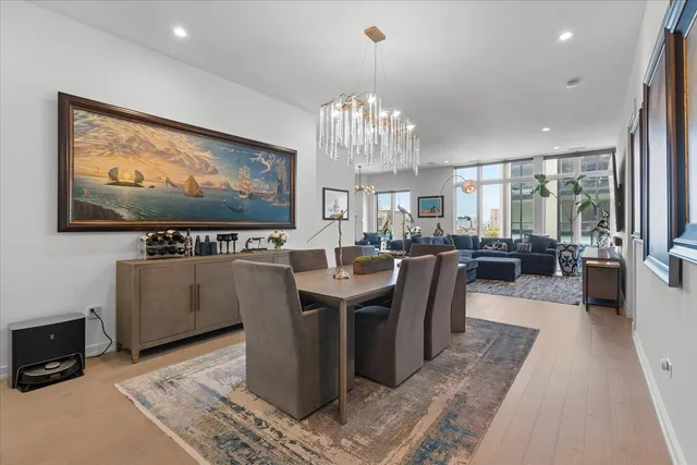 a view of a dining room with furniture a chandelier and wooden floor