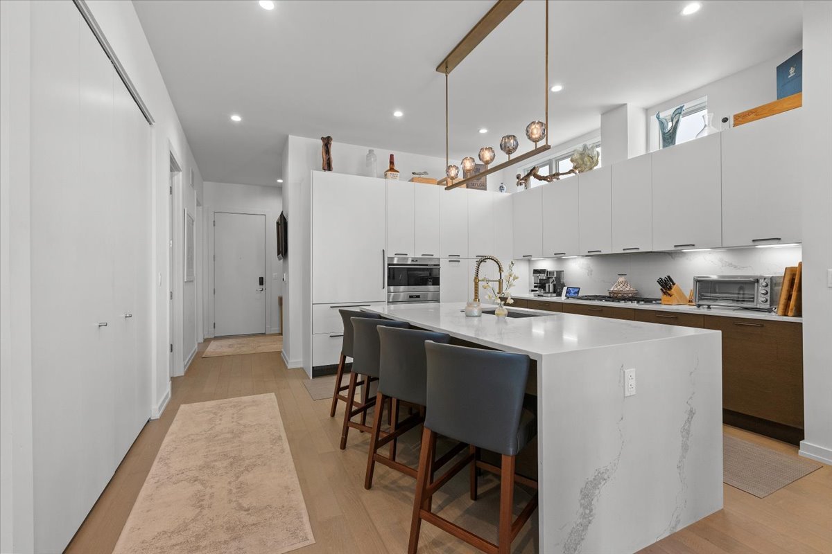 2773 North Hampden Court, Unit PH03 Chicago, IL 60614 - Photo 9 of 37 a kitchen with kitchen island a refrigerator stove and a sink with wooden floor