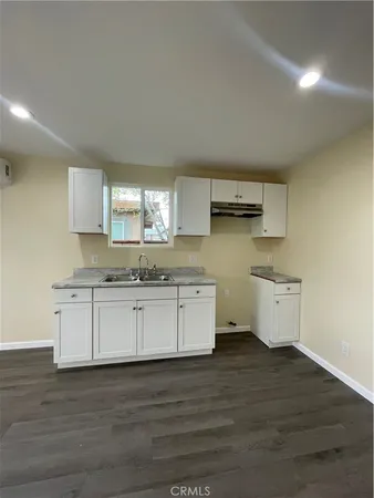 a view of an empty room with wooden floor and closet