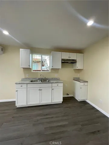 a view of an empty room with wooden floor and closet