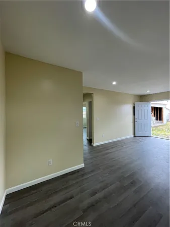 a large kitchen with a wooden floor and window
