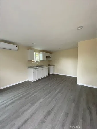 a view of a kitchen with wooden floor and a sink