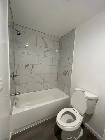 a white toilet sitting next to a bath tub and a shower