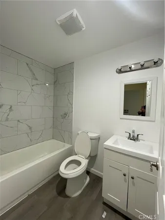 a bathroom with a toilet a sink a mirror and bathtub