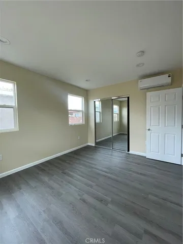 an empty room with wooden floor and mirror
