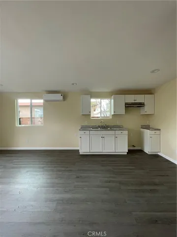 a kitchen with granite countertop white cabinets and wooden floor