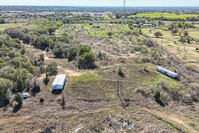 an aerial view of house with yard and mountain view in back