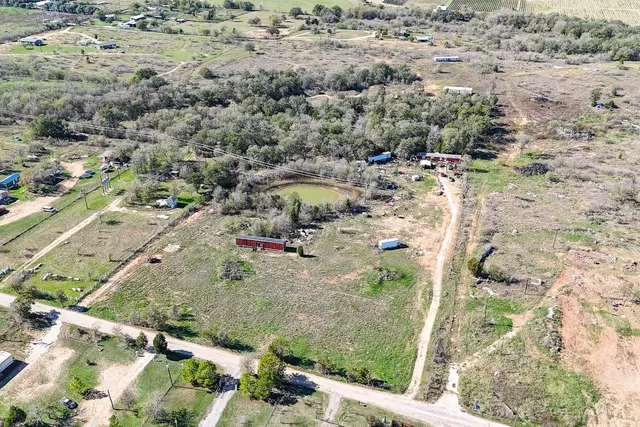 an aerial view of a house with a yard and swimming pool