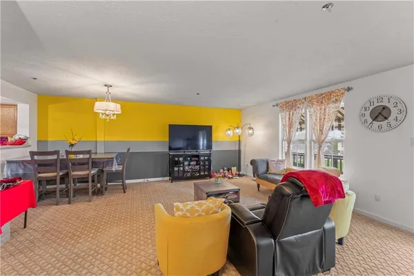a living room with furniture a flat screen tv and a large window
