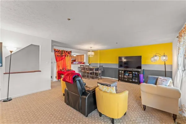 a living room with furniture a flat screen tv and a large window