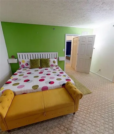a bedroom with a bed and a painting on the wall