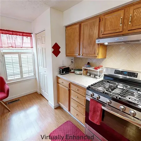 a kitchen with stainless steel appliances granite countertop a stove a sink dishwasher and cabinets with wooden floor