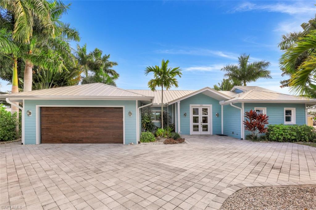 a view of a house with a yard and palm trees