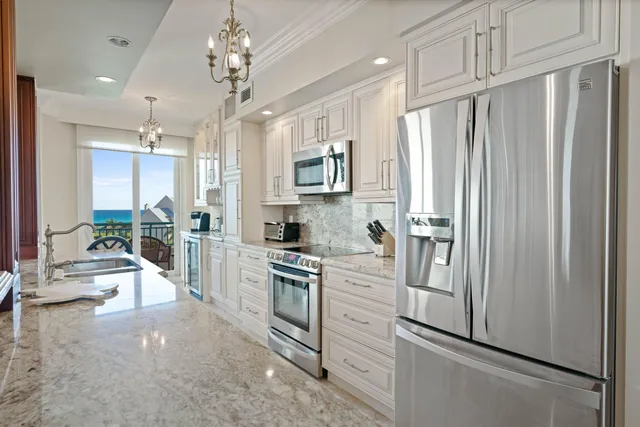 a bathroom with a granite countertop sink a large mirror and a bathtub next to a window