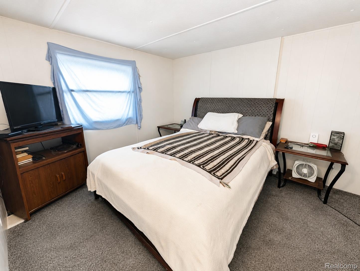 643 North Hockaday Road Gladwin, MI 48624 - Photo 8 of 24 Carpeted bedroom featuring white panel walls and a window with light-filtering privacy covering