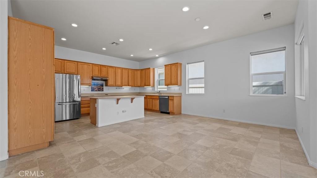 1706 Brittney Road Beaumont, CA 92223 - Photo 11 of 44 a large kitchen with stainless steel appliances granite countertop a stove a sink dishwasher and a refrigerator