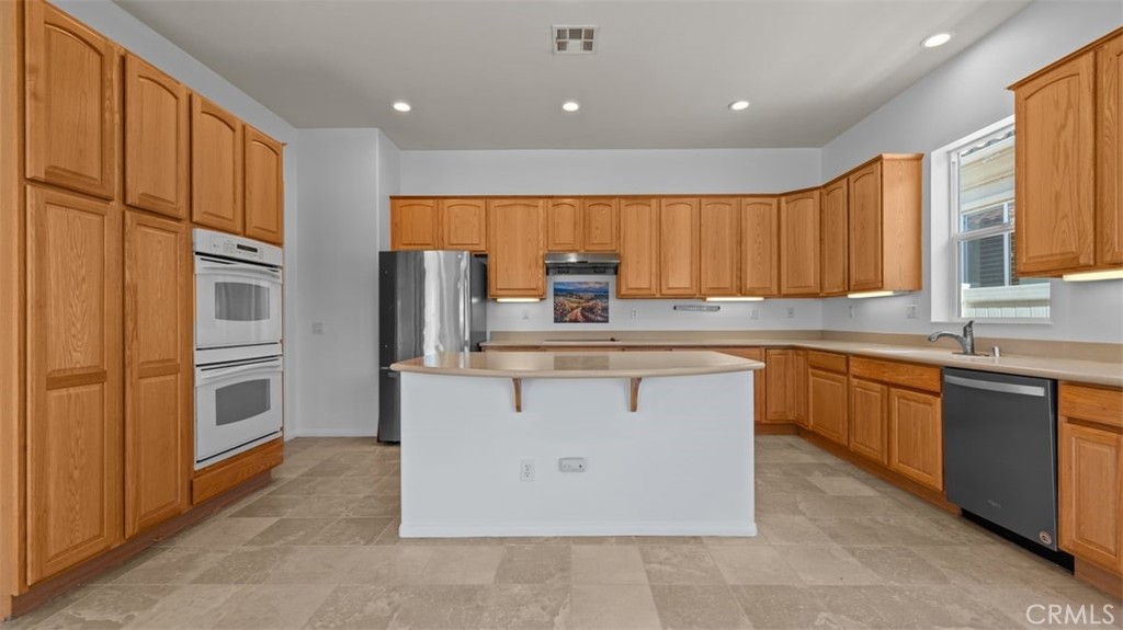 1706 Brittney Road Beaumont, CA 92223 - Photo 13 of 44 a kitchen with stainless steel appliances granite countertop a refrigerator a sink a stove a microwave and island