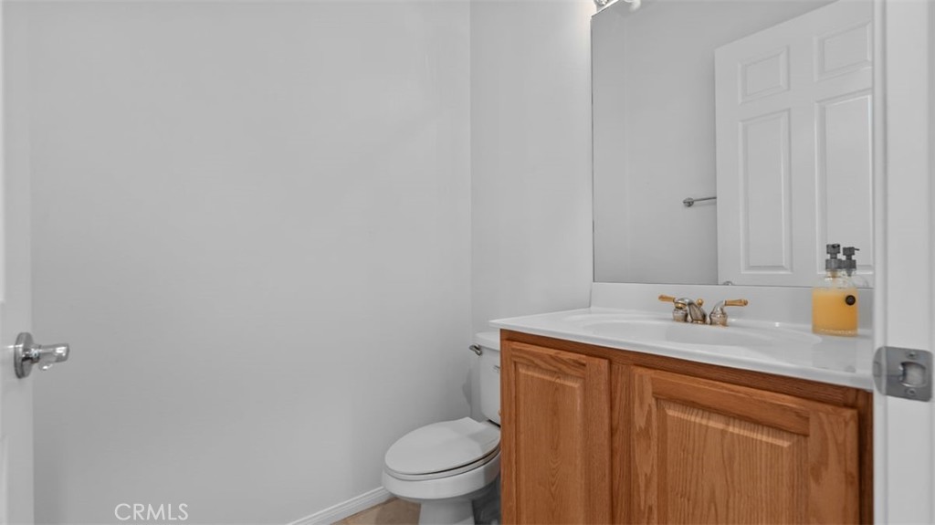 1706 Brittney Road Beaumont, CA 92223 - Photo 25 of 44 a bathroom with a granite countertop sink toilet and a mirror