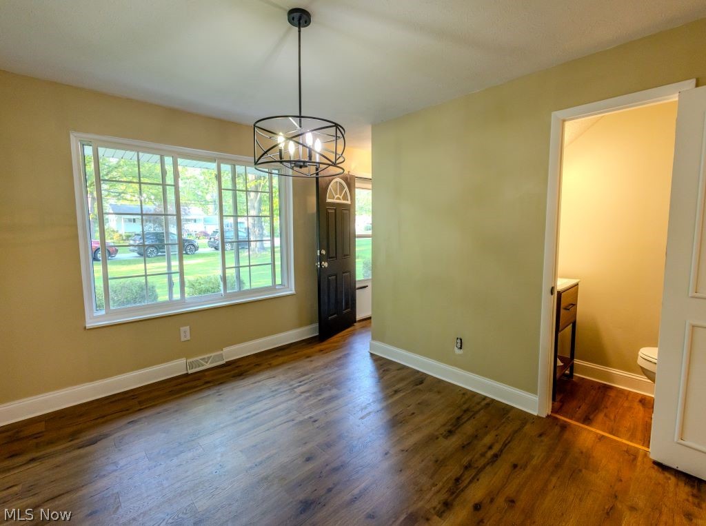 8828 Edgehill Road Mentor, OH 44060 - Photo 11 of 24 Spare room with a notable chandelier, plenty of natural light, and dark wood-type flooring