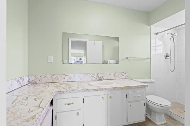 a bathroom with a sink toilet a mirror and shower