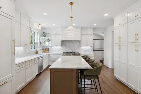a living room with furniture a fireplace and a chandelier