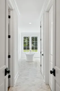 a view of the house with a yard and large trees