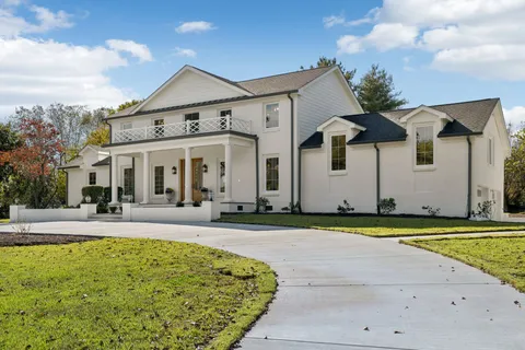 a front view of a house with swimming pool and porch