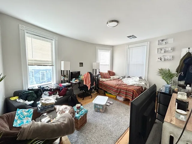 a living room with furniture a flat screen tv and a large window