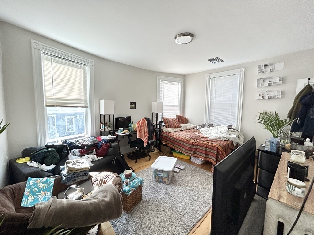 9 Mt Pleasant Avenue, Unit 2 Boston, MA 02119 - Photo 8 of 9 a living room with furniture a flat screen tv and a large window