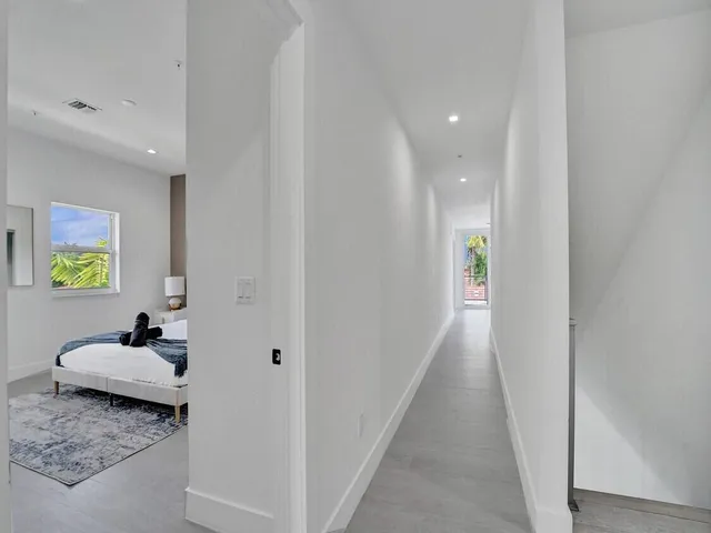 a living room with furniture and a hallway